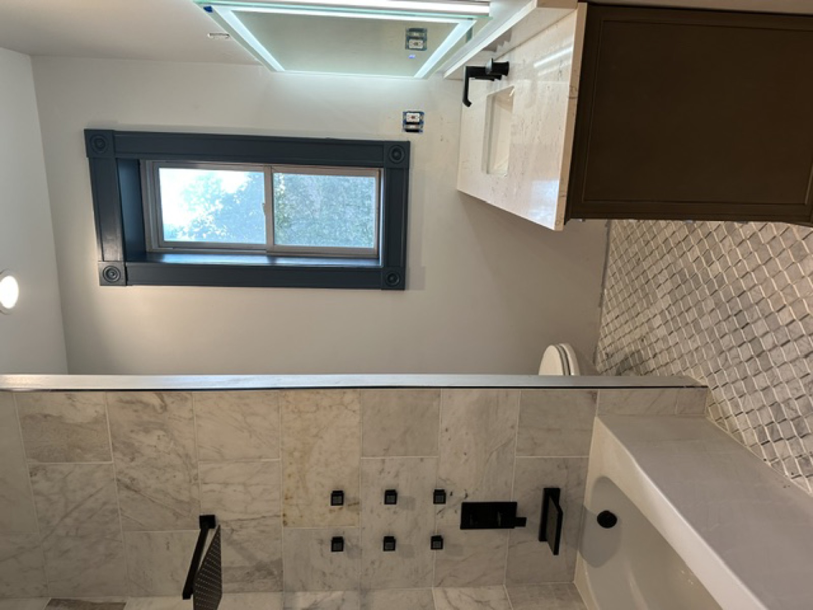 Spa bathroom remodel — marble tile, soaking tub, black hardware