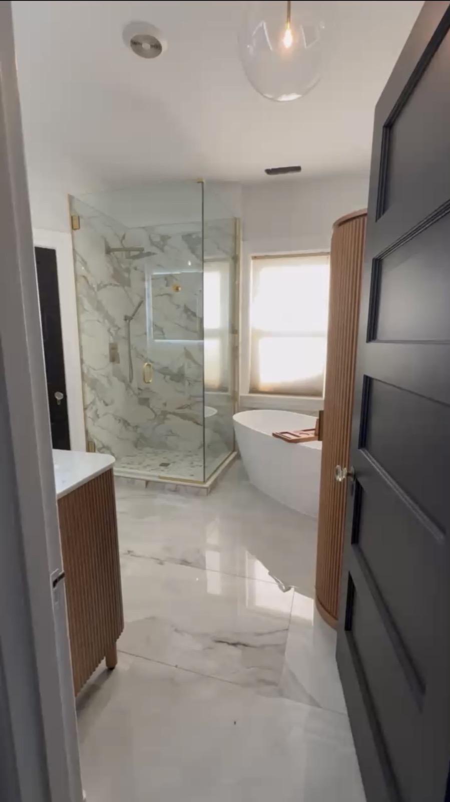 Luxury master bath — marble floors, freestanding tub, glass shower