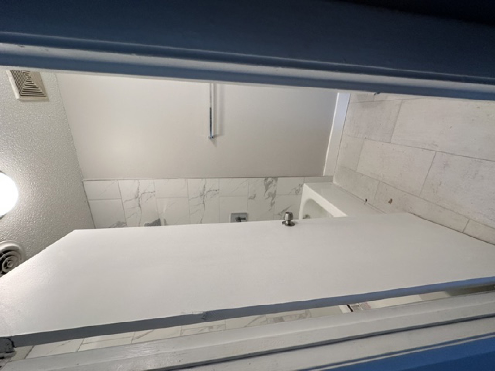 Completed bathroom renovation — white tile and fixtures