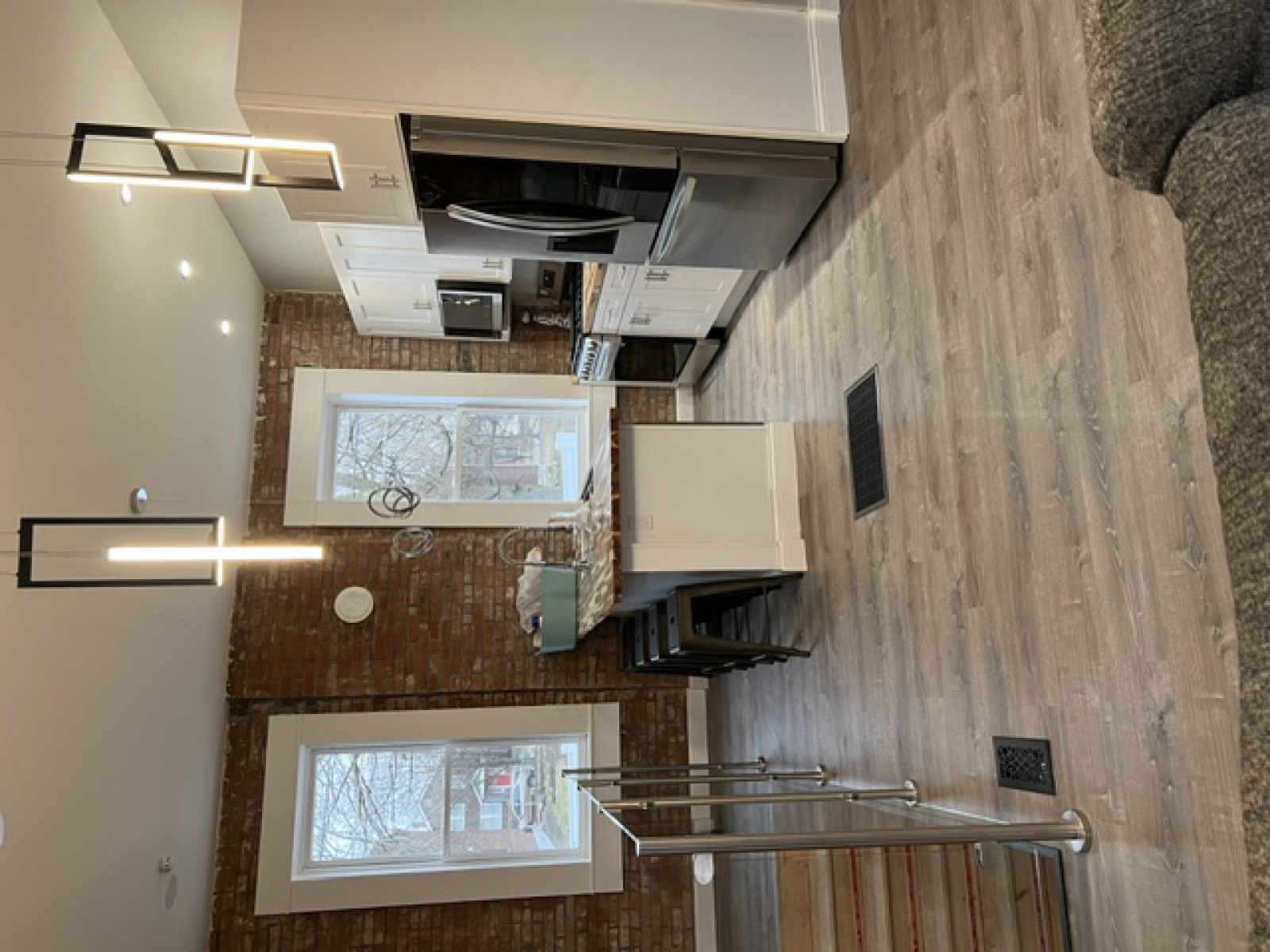 Open-concept kitchen with exposed brick wall and pendant lighting