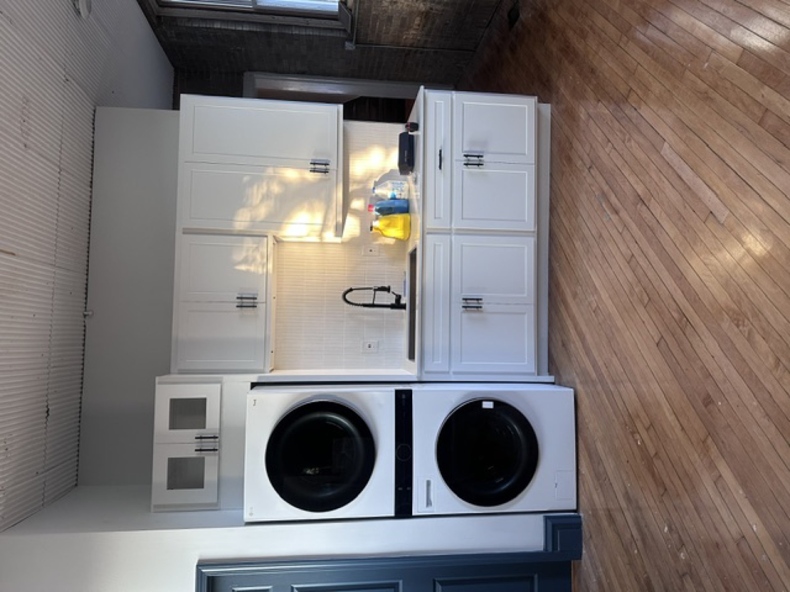Finished laundry room — stacked washer/dryer with custom cabinetry